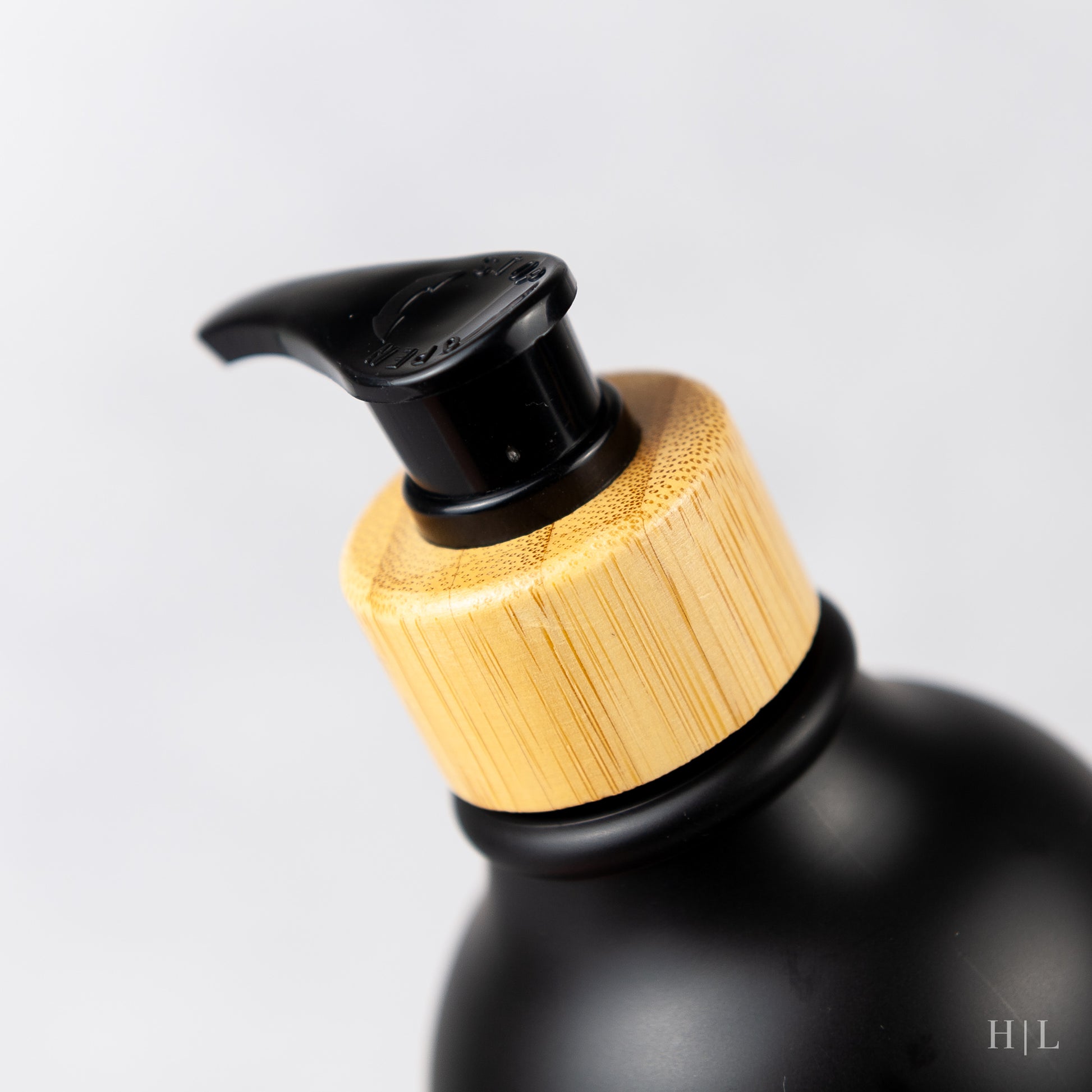 a black bottle with a wooden lid and a black cap