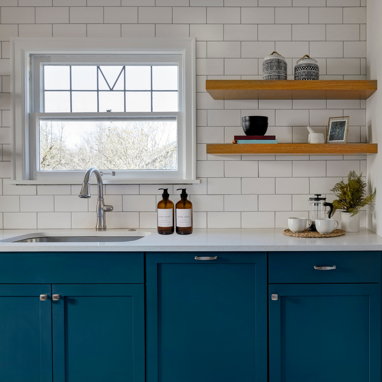 a kitchen with blue cabinets and a white tiled wall